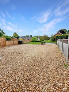 a gravel driveway in a yard with a fence at Amaya Eleven - 3 bed cottage in village in Harlaxton