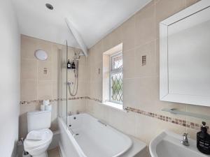 a bathroom with a tub and a toilet and a sink at Amaya Eleven - 3 bed cottage in village in Harlaxton
