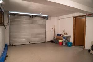 an empty garage with a large metal garage door at Villa Maria Amalia in Tsagarada +42 photos