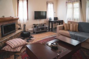 a living room with a couch and a television at Villa Maria Amalia in Tsagarada