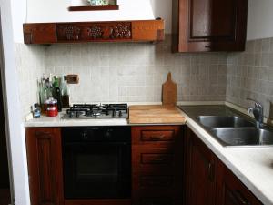 a kitchen with a black stove and a sink at Charming Tuscan Farmhouse in San Lorenzo a Merse