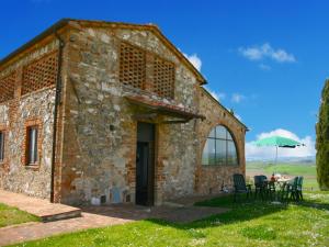 a stone barn with a table and chairs in front of it at Charming Tuscan Farmhouse in San Lorenzo a Merse