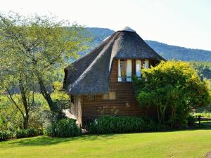 a small wooden house with a thatched roof at ANEW Resort Ingeli Forest Kokstad in Kokstad