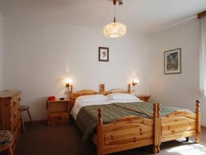 a bedroom with a wooden bed and a wooden dresser at Hotel Ancora in Moena