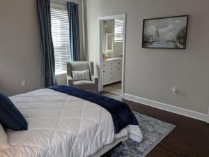 une chambre avec un lit, une chaise et un miroir dans l'établissement Serenity Cottage, à Thomasville