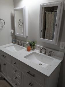 une salle de bains avec un lavabo blanc et un miroir dans l'établissement Serenity Cottage, à Thomasville 30 autres photos