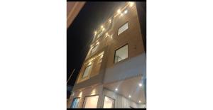 a building with lights on the side of it at night at Shree Aaradhya Suites in Khātu +12 photos