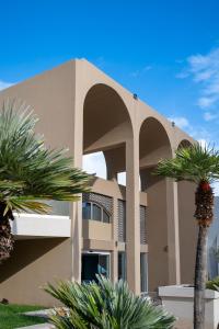 a building with a palm tree in front of it at Royal & Imperial Belvedere Resort in Hersonissos