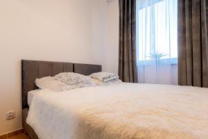 a bedroom with a white bed with a large window at Gicek Apartament 11B bezpłatny PARKING Faktura VAT 4 osobowy K-S SSE in Gorzów Wielkopolski