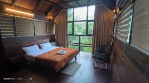 a bedroom with a bed in a room with windows at Moonrise Valley Freshwave Resorts Pvt Ltd in Koroth