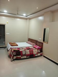 a bedroom with a bed and a tv on the wall at Hotel parbramha in Pandharpur