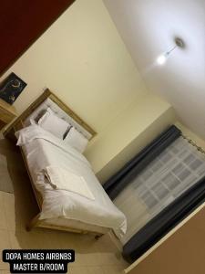 a bedroom with a bed with white sheets and pillows at Dopa Homes Airbnbs in Meru