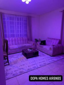 a purple living room with a couch and a table at Dopa Homes Airbnbs in Meru