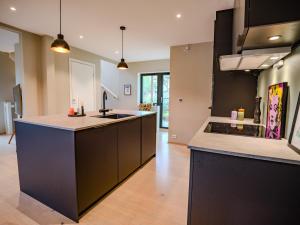 a kitchen with black cabinets and a kitchen island at Central apartment in Tromsø