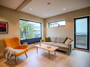 a living room with a couch and a table and two windows at Central apartment in Tromsø