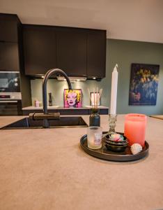a kitchen counter with a candle and a sink at Central apartment in Tromsø