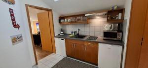 eine kleine Küche mit Spüle und Mikrowelle in der Unterkunft Appartement in Berghäuser mit Sonnigem Balkon in Grafenwiesen