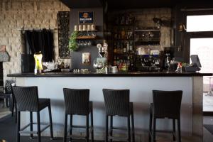 a bar with four chairs at a counter at La Jalousie in Saint-Aignan-de-Cramesnil