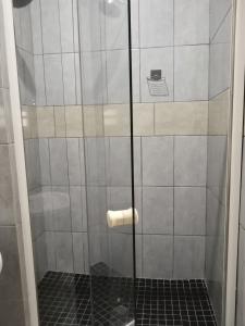 una doccia con una porta in vetro in un bagno di Capital Park entire rental unit a Pretoria