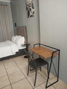 Camera con letto, tavolo e sedia di Capital Park entire rental unit a Pretoria
