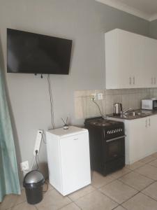 una cucina con una stufa nera e un frigorifero bianco di Capital Park entire rental unit a Pretoria