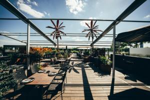 a patio with tables and chairs and palm trees at Kameha Grand Bonn in Bonn +196 photos