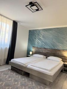 a bedroom with a bed with a painting on the wall at Relax House El Passo in Târgu-Mureş