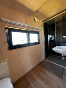 un piccolo bagno con lavandino e finestra di Tiny House du Gad Bourgeois a Chièvres