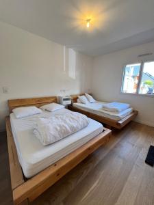 due letti in una stanza con strutture in legno di Appartements Prestiges I Draps&ménage inclus I parking privé a Saint-Lary-Soulan