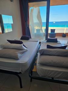 Tres camas en una habitación con vista al mar. en White Suites Ibiza, en Playa d'en Bossa