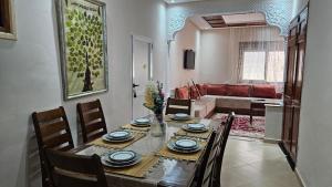 a dining room with a table and chairs and a living room at Dar Boujida in Larache