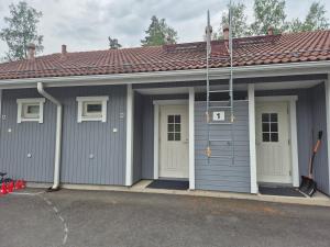 a gray garage with white doors and a red roof at Rivitalo kylpylän lähellä in Kilvakkala