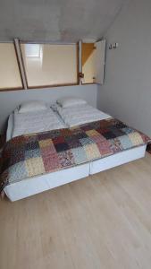 Una cama con una colcha encima en una habitación. en Rivitalo kylpylän lähellä, en Kilvakkala