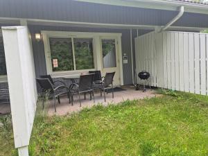un patio con sillas, una mesa y una parrilla en Rivitalo kylpylän lähellä, en Kilvakkala
