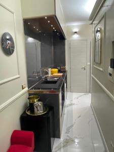 a kitchen with a sink and a red stool at The Madame Sofia - A Secret Hotel - Small Boutique Hotel & Apartments in Rome