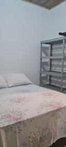 Un dormitorio con una cama con una manta floral. en Apartamentos da Casa Azul, en Trancoso