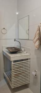 un baño con lavabo y espejo en Apartamentos da Casa Azul, en Trancoso