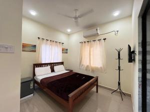 a bedroom with a bed and a air conditioner at The cozy Inn in Calangute