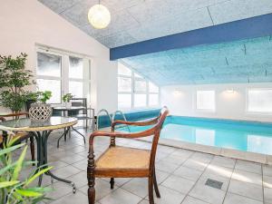 a living room with a pool and a table and a chair at 14 person holiday home in Sæby in Sæby