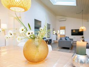 a vase filled with flowers sitting on top of a table at 5 star holiday home in Sæby in Sæby +34 photos