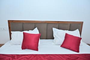 a bed with red and white pillows on it at Hotel Dream Place in Pāl