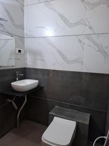 een badkamer met een wit toilet en een wastafel bij Darsh Resort in Sasan Gir