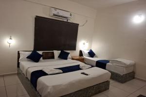 een hotelkamer met twee bedden met blauwe kussens bij Darsh Resort in Sasan Gir +11 foto's