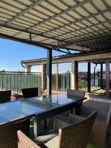 a patio with a table and chairs on a deck at Pensiunea El Passo Targu Mures in Târgu-Mureş