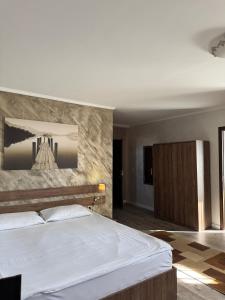 a bedroom with a large bed with a stone wall at Pensiunea El Passo Targu Mures in Târgu-Mureş +39 photos