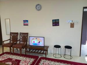 a living room with a tv and two chairs at Homestay No 68 Raub in Raub