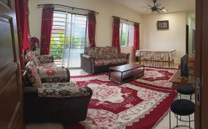 a living room with a couch and chairs and a table at Homestay No 68 Raub in Raub