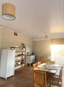 a kitchen with a table and a white refrigerator at Beira Rio Casa Canastra in Vargem Bonita