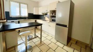 a kitchen with a refrigerator and a table in it at Charmevolles Ferienrefugium in Wiesbaden