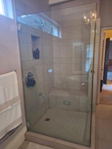 开普敦Bishopsfield Guesthouse Rondebosch的浴室里有玻璃门的淋浴间